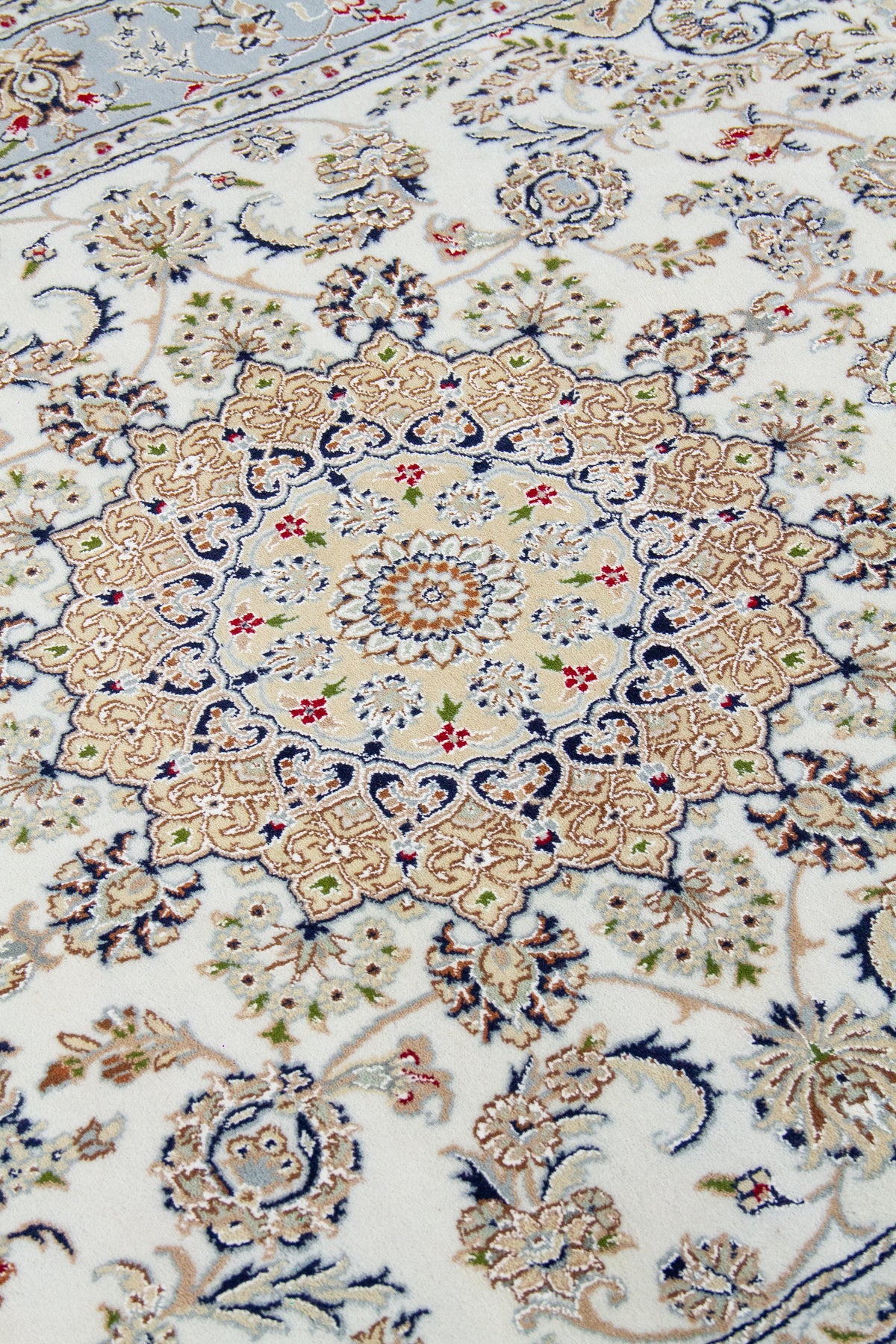 Detalle de textura y medallón central de alfombra persa beige con diseño floral