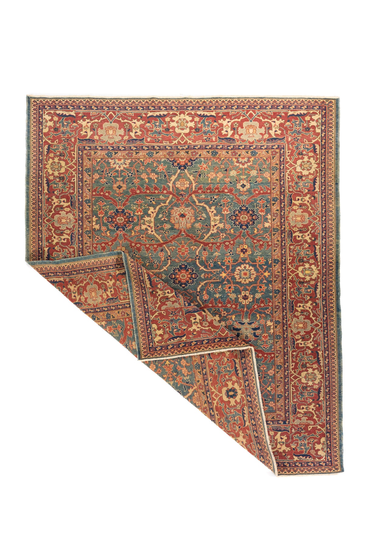 La esquina levantada permite apreciar la caída natural de la alfombra, parte del reverso y la continuidad del diseño entre el centro y los bordes. Esta imagen resalta el trabajo artesanal y la estructura de la pieza.