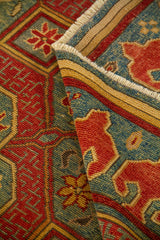 La alfombra aparece parcialmente doblada, mostrando su textura, la definición del tejido y el acabado de los flecos. Esta toma destaca la minuciosidad del diseño y la riqueza ornamental del patrón