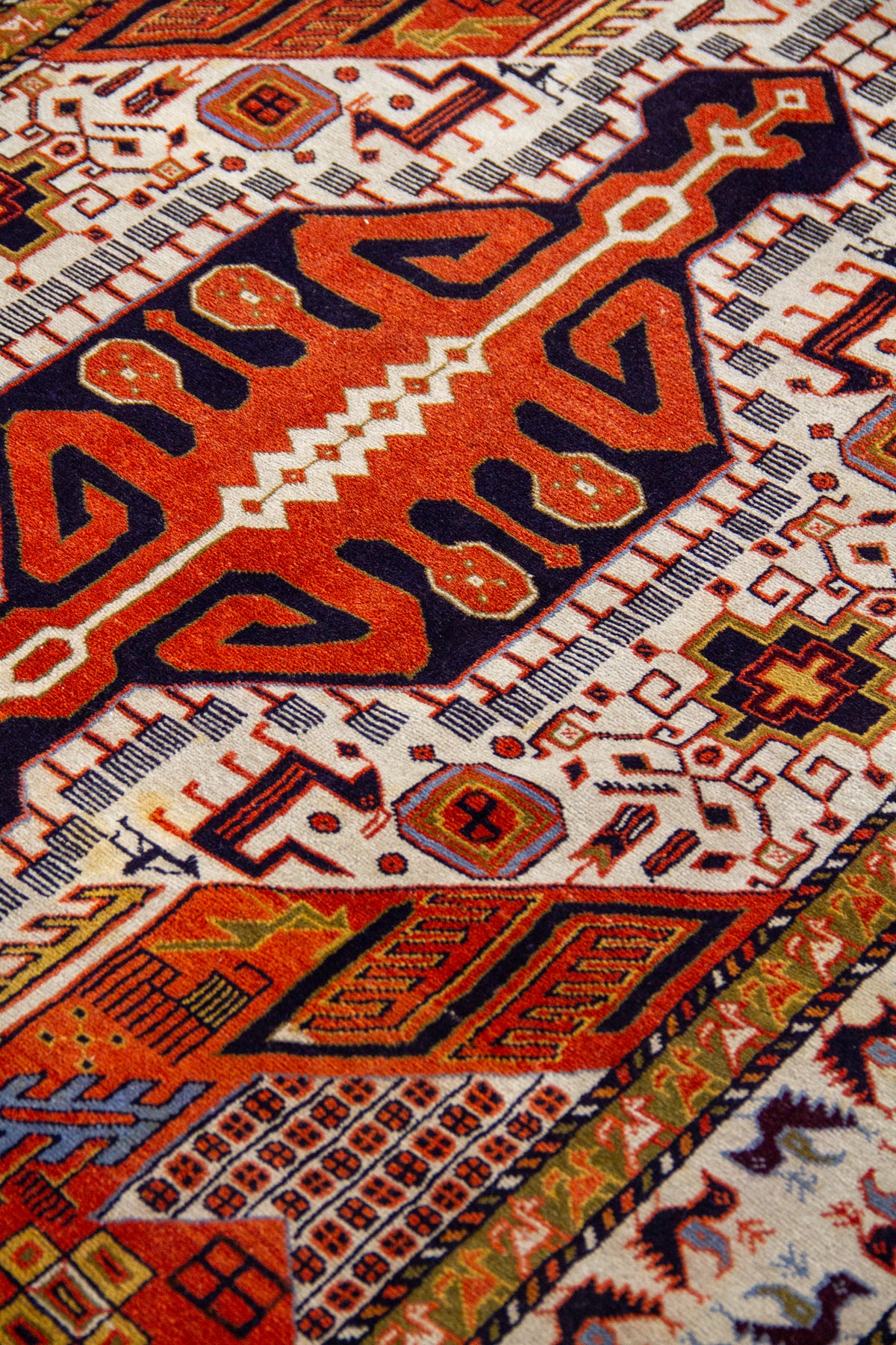 Detalle del diseño central de alfombra Persa Sarouk con medallón geométrico naranja y negro