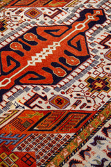 Detalle del diseño central de alfombra Persa Sarouk con medallón geométrico naranja y negro