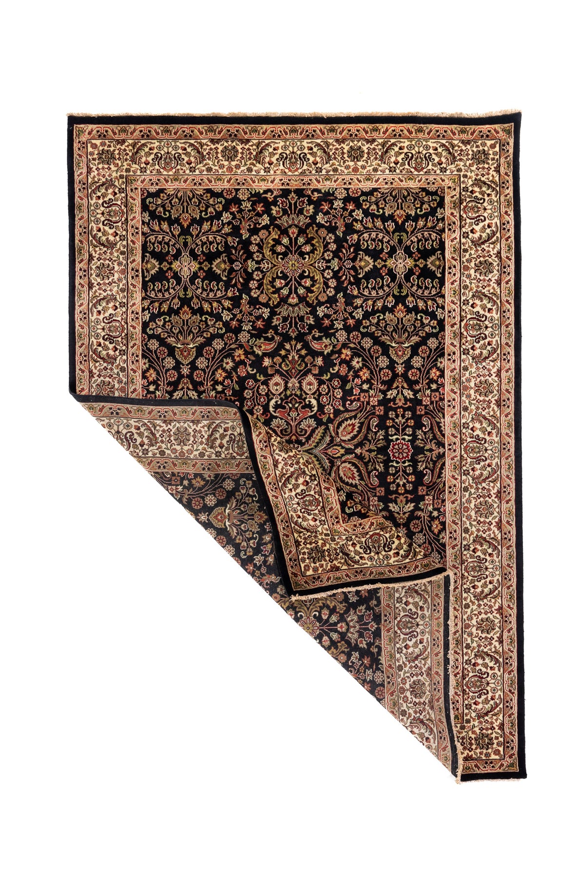 Alfombra oriental en tonos negro y blanco suave con una esquina doblada, mostrando el reverso del tejido y parte de su diseño floral clásico.