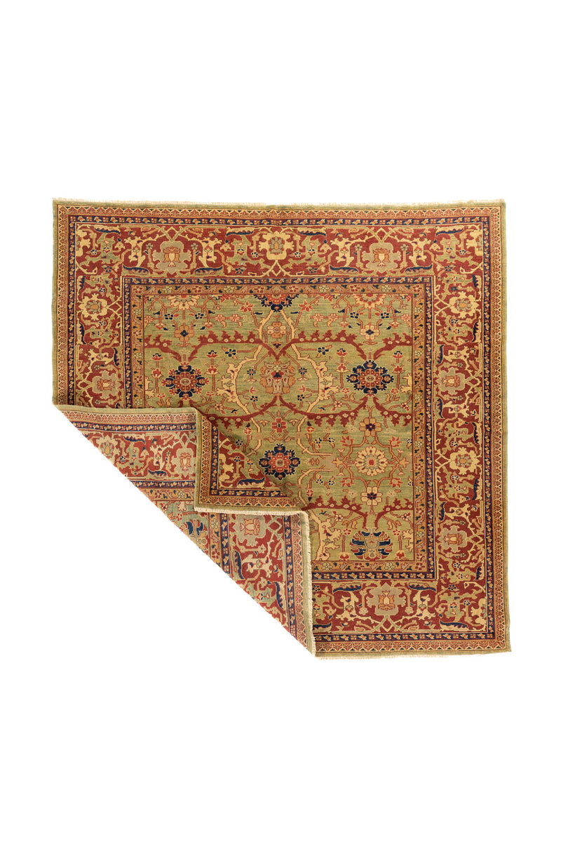 La esquina levantada permite apreciar la caída natural de la alfombra, su flexibilidad y parte del reverso del tejido. Esta imagen resalta la continuidad del diseño ornamental y el carácter artesanal de la pieza.