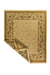 Alfombra decorativa clásica con una esquina doblada que permite ver el reverso del tejido y su diseño de inspiración floral