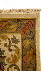 Detalle del borde superior de alfombra clásica con diseño ornamental, hojas estilizadas y acabado con flecos claros