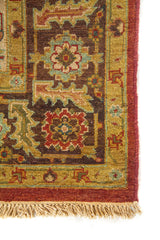 Detalle de borde de alfombra oriental con flores geométricas y combinación de tonos rojo, beige y verde