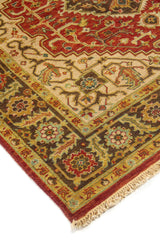 Acercamiento lateral de alfombra oriental con patrones geométricos, borde decorativo ancho y flecos en tono beige.
