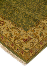 Primer plano de alfombra decorativa con diseño vegetal en tonos verdes, beige y toques burdeos en la guarda