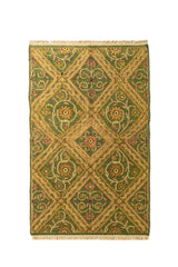 Alfombra de diseño geométrico en tonos verde oscuro, dorado y rojo suave, con patrón de rombos repetidos y flecos en los extremos.