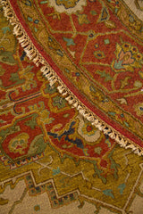 Acercamiento de la alfombra doblada mostrando la textura del tejido, la guarda ornamental y los flecos laterales.
