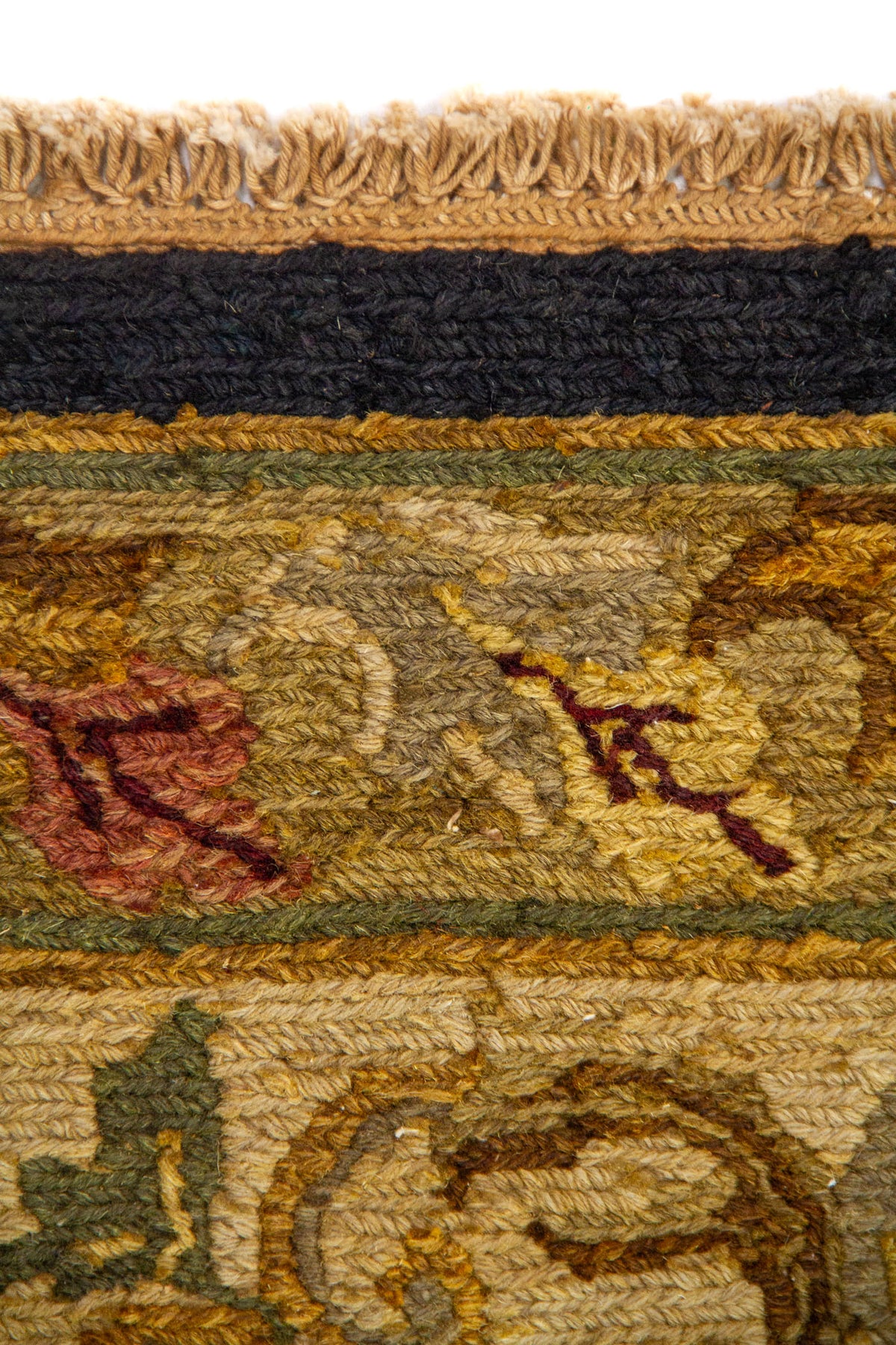 Detalle de borde de alfombra clásica con flores estilizadas, enredaderas y acabado en tono azul marino