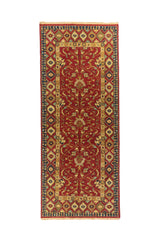 Alfombra pasillera en tonos rojo, azul y beige con centro floral estilizado y guarda geométrica de rombos