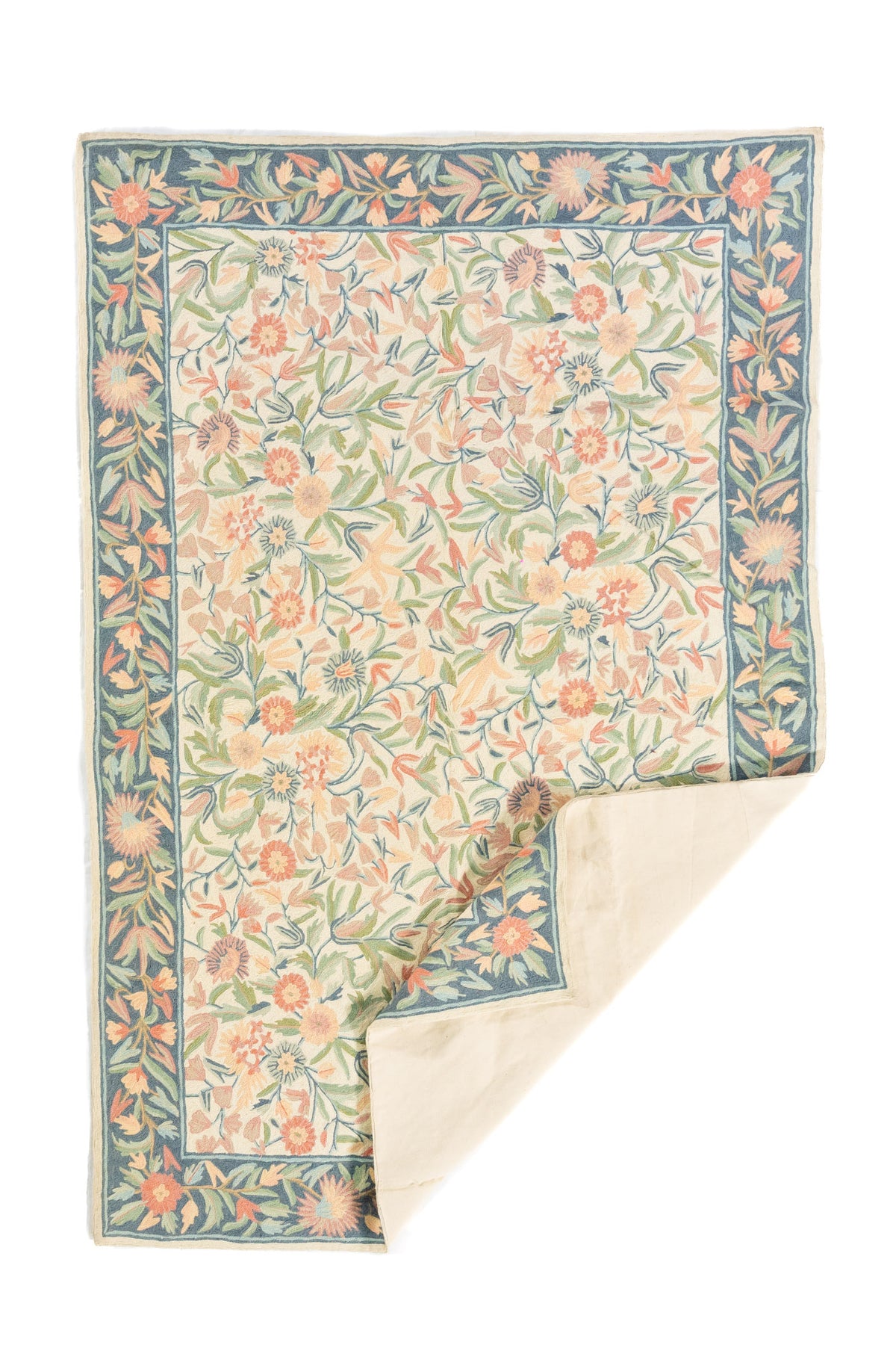 Alfombra floral rectangular con esquina doblada mostrando el reverso en tono beige claro