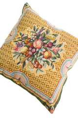 Detalle del diseño floral de almohadón beige con frutos, hojas y guarda ornamental