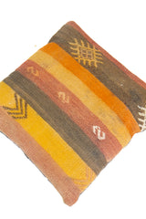 Detalle de textura de almohadón kilim con rayas verticales y motivos geométricos en tonos cálidos