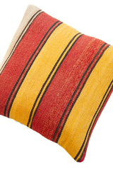Detalle de textura de almohadón kilim con rayas horizontales en rojo, amarillo y negro