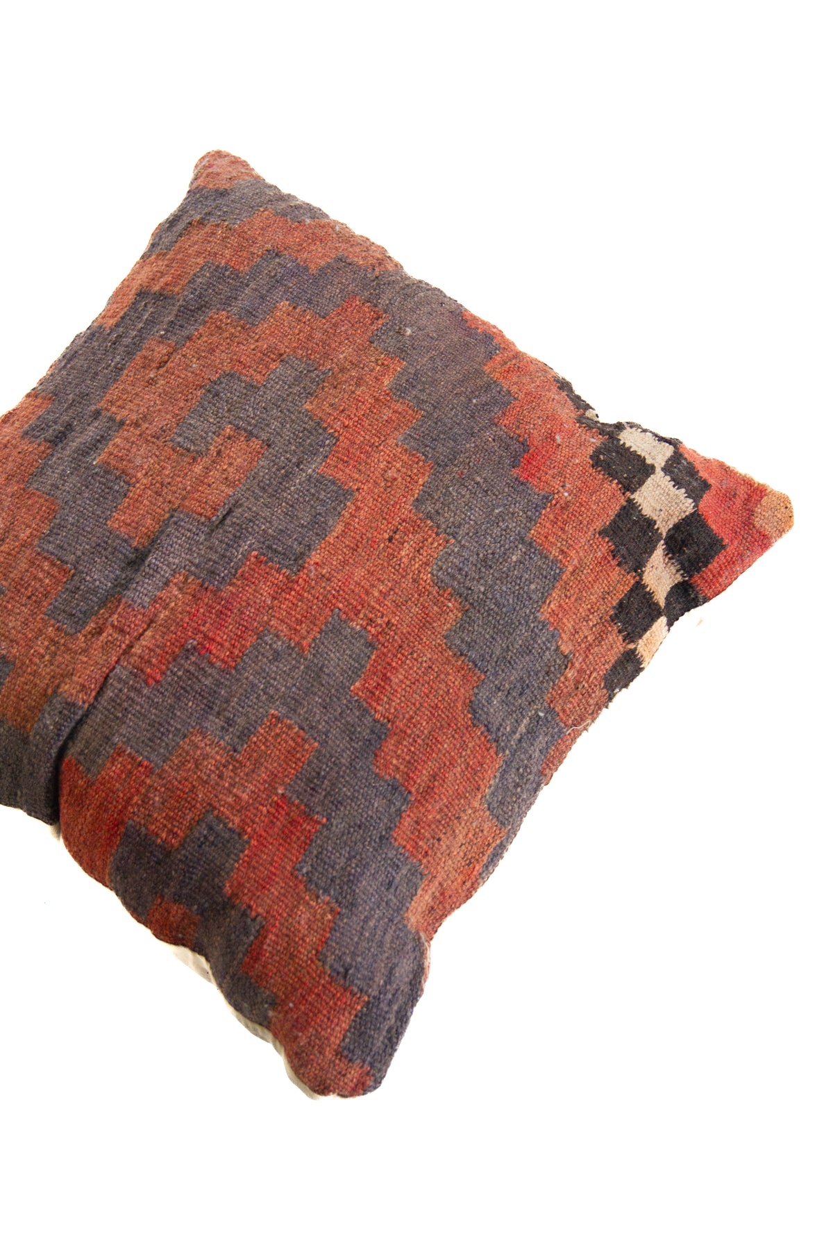Detalle de textura de almohadón kilim con patrón geométrico tribal en marrón y gris oscuro