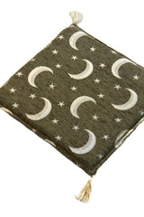 Detalle de almohadón Kayseri Luna Verde con textura, medias lunas claras y estrellas bordadas.