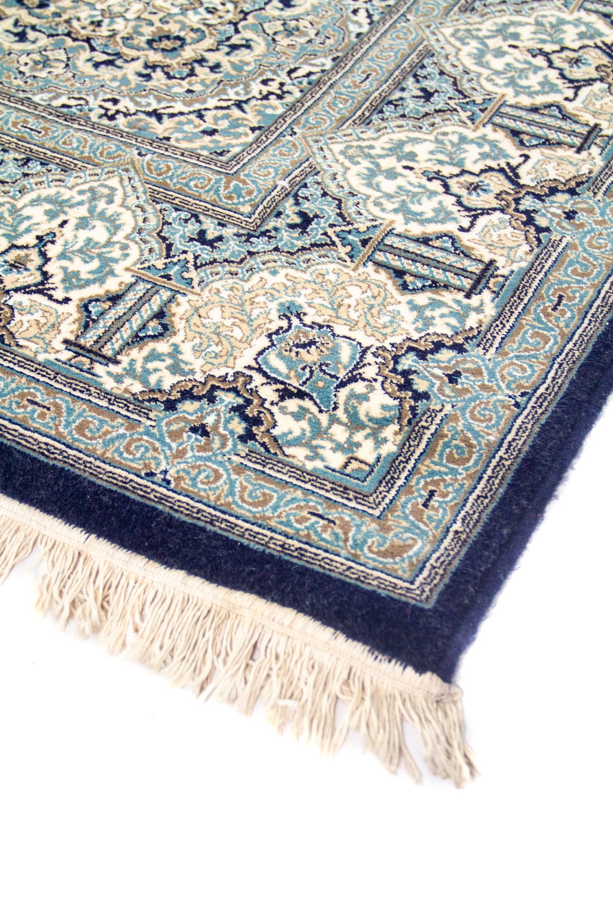 Detalle cercano del borde de la alfombra, resaltando los patrones geométricos y la textura del tejido