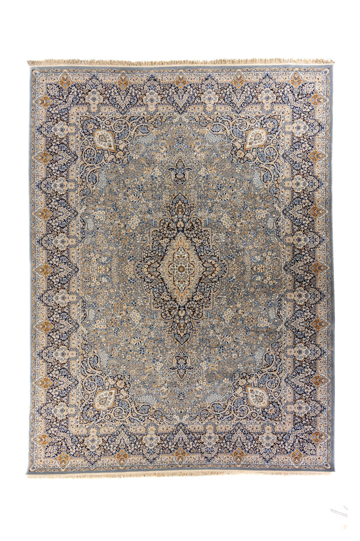 Vista cenital completa de la alfombra con diseño simétrico floral en tonos suaves de gris, azul y dorado.