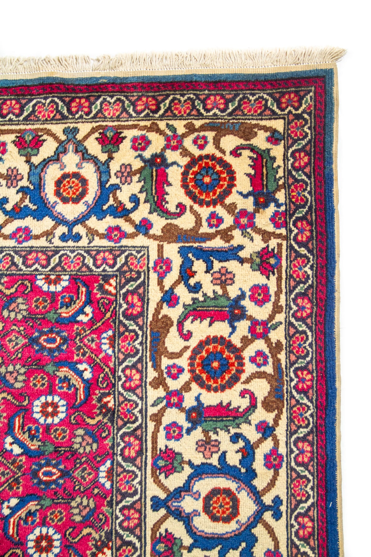 Primer plano de borde de alfombra oriental roja con guarda beige, flores estilizadas y acabado artesanal