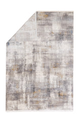 Alfombra moderna con esquina doblada, mostrando su reverso y diseño abstracto en tonos neutros.