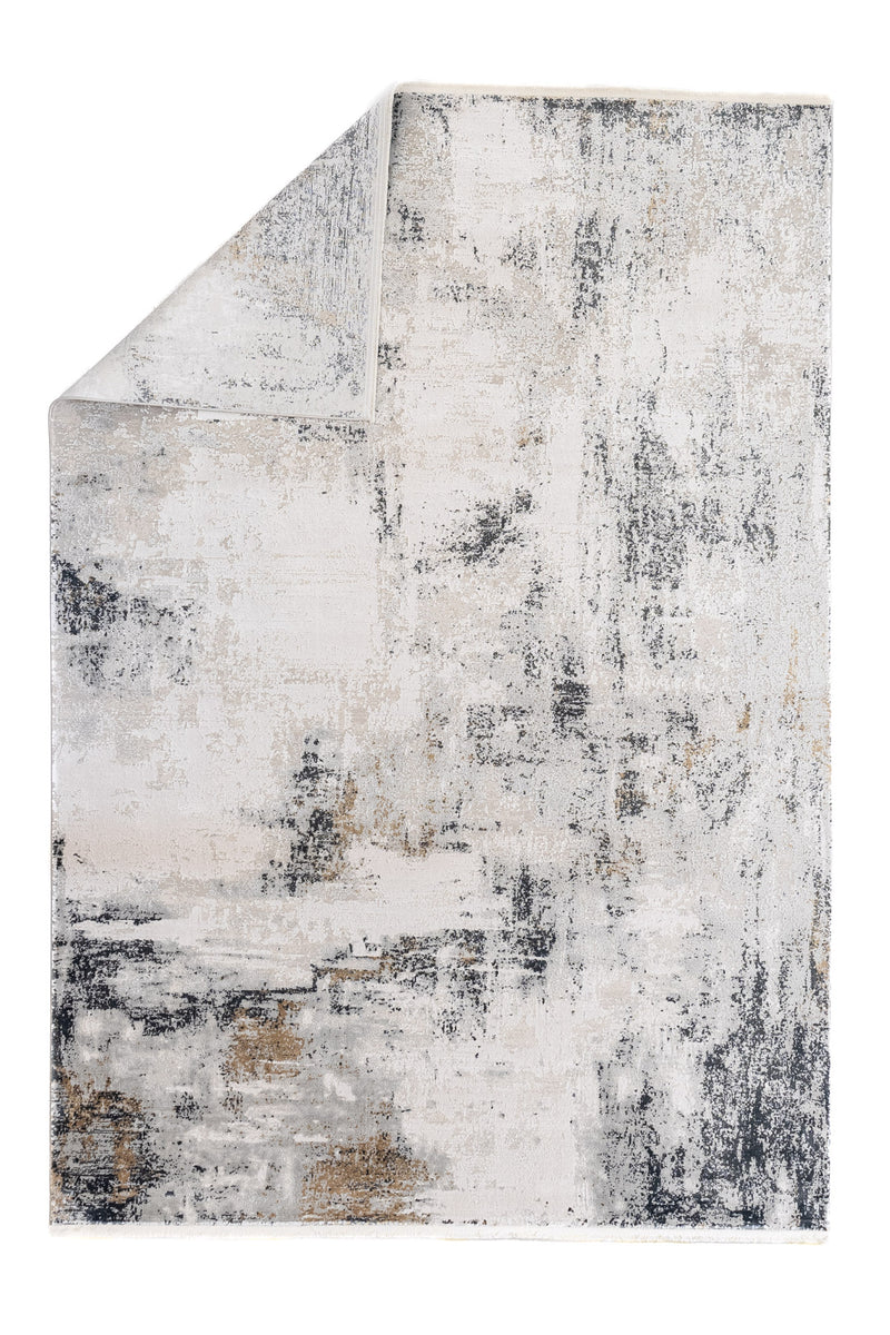 Alfombra moderna con patrón artístico en degradé, tonos neutros y acabado texturizado visto desde una esquina doblada.