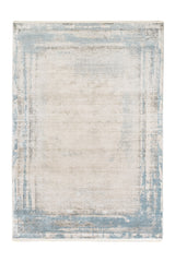 Vista completa de una alfombra contemporánea rectangular en tonos beige con un sutil marco azul celeste y textura envejecida.