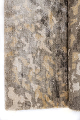 Primer plano de la textura de la alfombra, destacando los hilos gruesos en beige, gris y dorado