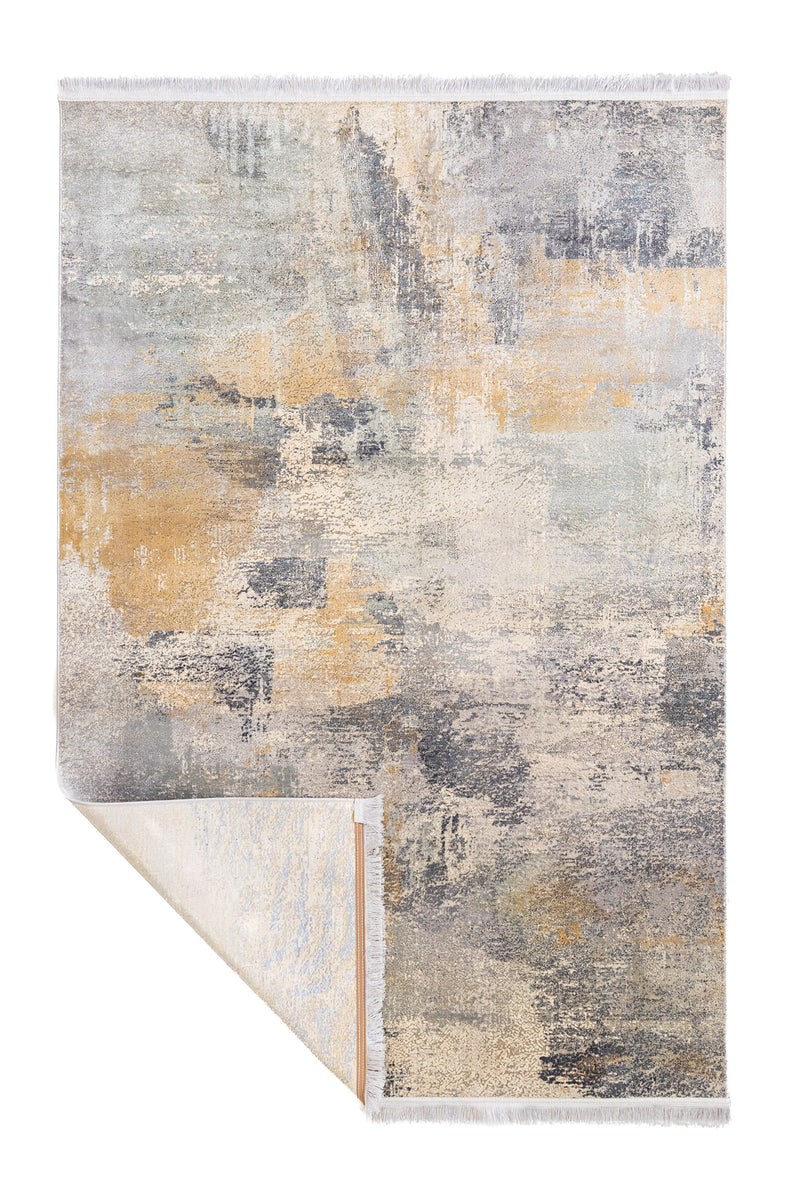 Vista de la alfombra con la esquina inferior doblada, mostrando reverso y flecos blancos.