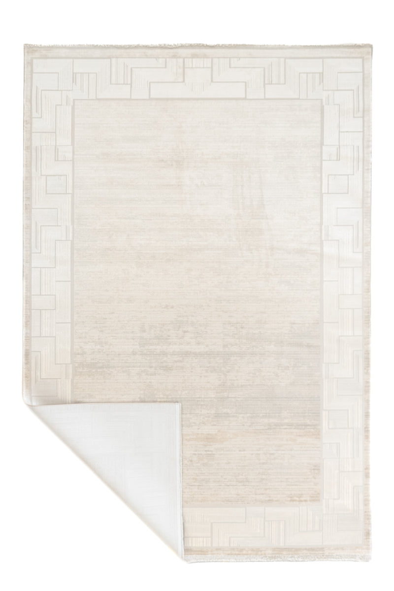 Alfombra contemporánea color marfil con una esquina doblada mostrando el reverso.