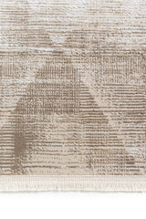 Detalle del borde inferior de la alfombra con flecos y textura en tonos beige.
