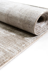 Alfombra enrollada que resalta su flexibilidad y textura moderna en tonos neutros.