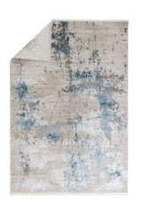 Alfombra contemporánea con la esquina doblada, mostrando diseño abstracto en tonos fríos y cálidos.
