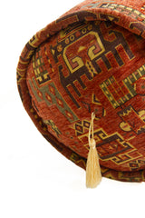 Detalle de textura de almohadón caramelo marrón con motivos geométricos y borla decorativa