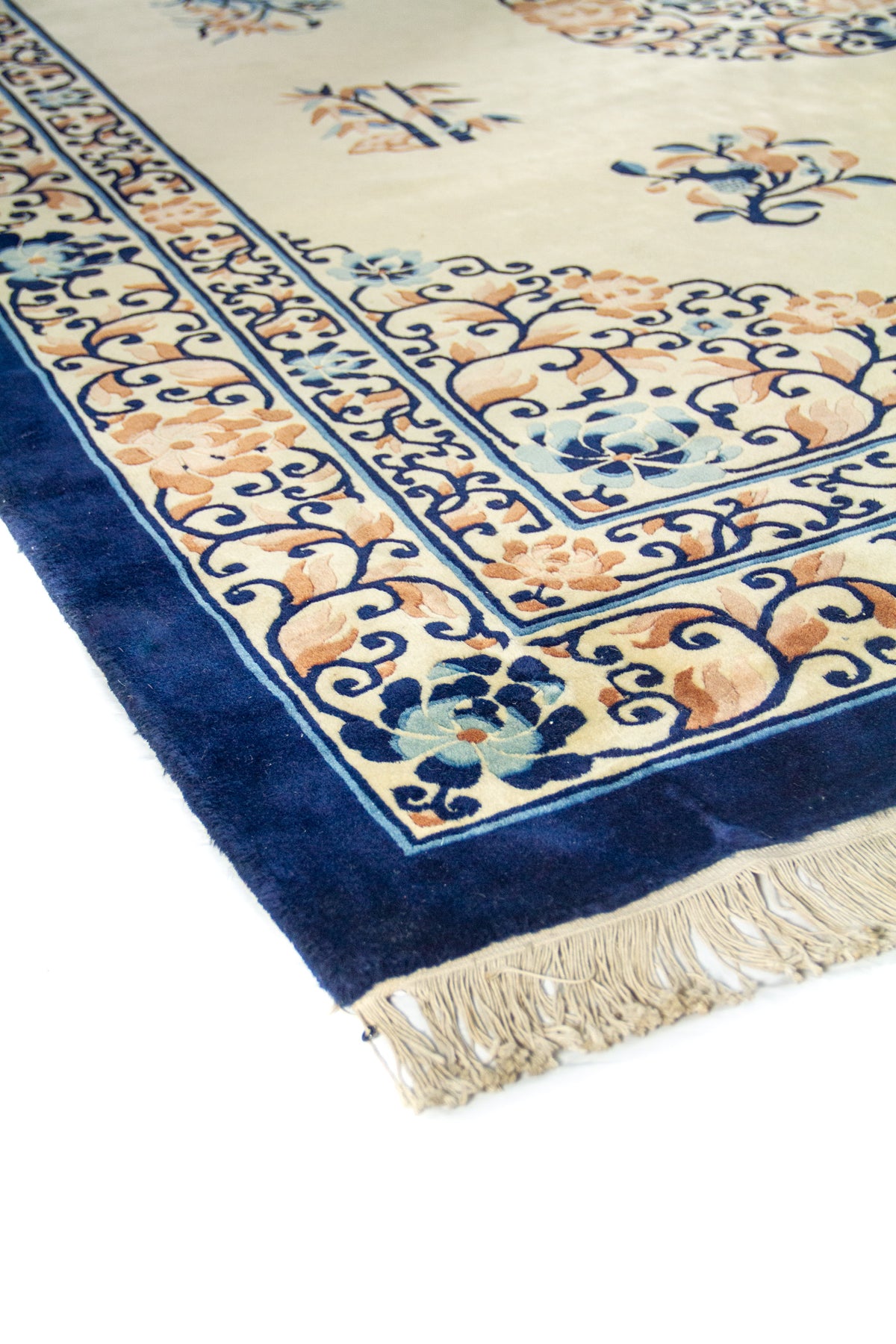 Primer plano en ángulo del marco floral con arabescos azules y flores claras sobre fondo beige.