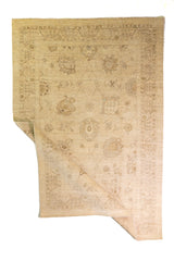 Alfombra Persa Isfahan beige de 1.83 x 2.68 mts, vista completa con una esquina doblada; se observan ornamentación floral clara y guardas delicadas