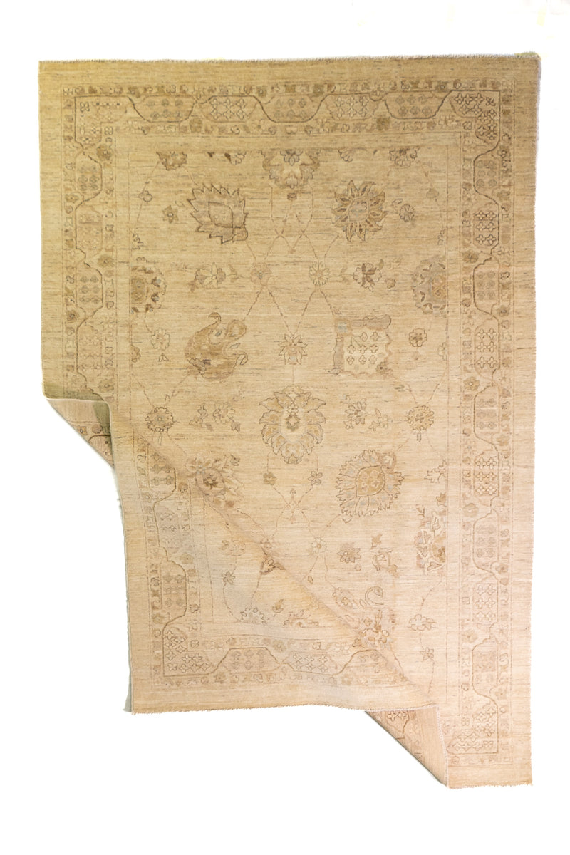 Alfombra Persa Isfahan beige de 1.83 x 2.68 mts, vista completa con una esquina doblada; se observan ornamentación floral clara y guardas delicadas