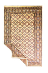 Alfombra Persa Bukara Yamouth beige de 1.88 x 2.90 mts, vista completa con una esquina doblada; se observan retícula geométrica con detalles de color en las guardas