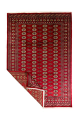Alfombra Persa Bukara rojo de 1.85 x 2.75 mts, vista completa con una esquina doblada; se observan columnas de medallones ovalados y guardas geométricas
