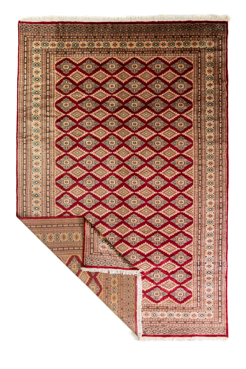 Alfombra Persa Yamouth beige y rojo de 1.88 x 2.82 mts, vista completa con una esquina doblada; se observan retícula borgoña sobre campo claro con guardas beige