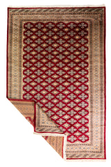 Alfombra Persa Yamouth rojo de 1.88 x 2.87 mts, vista completa con varias secciones dobladas, mostrando reverso y guardas; se observan retícula geométrica de motivos repetidos y guardas múltiples