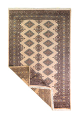Alfombra Persa Yamouth beige de 1.55 x 2.44 mts, vista completa con una esquina doblada; se observan motivos geométricos alargados y guardas oscuras