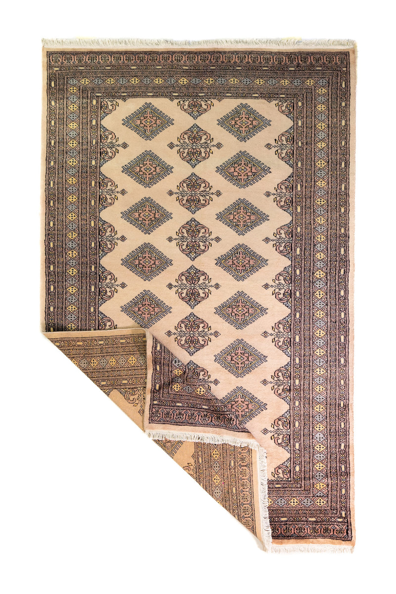 Alfombra Persa Yamouth beige de 1.55 x 2.44 mts, vista completa con una esquina doblada; se observan motivos geométricos alargados y guardas oscuras