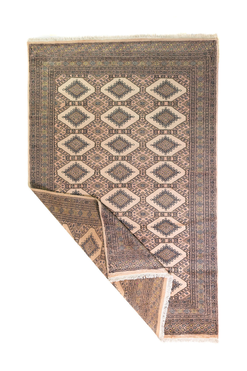 Alfombra Persa Yamouth marrón y beige de 1.52 x 2.44 mts, vista completa con una esquina doblada; se observan grandes rombos claros y guardas oscuras