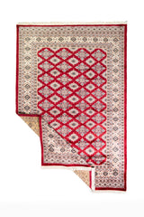 Alfombra Persa Yamouth rojo de 1.27 x 1.88 mts, vista completa con una esquina doblada; el diseño muestra una trama romboidal roja continua sobre un campo claro y un borde rojo definido