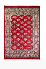 Alfombra Persa Yamouth rojo de 1.27 x 1.88 mts, vista completa vertical; el diseño muestra una retícula de rombos rojos enlazados con guardas geométricas de alto contraste