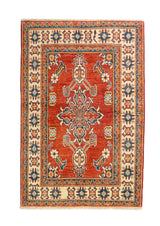 Alfombra Caucasica Kazak ladrillo y beige de 0.94 x 1.45 mts, vista completa vertical; el diseño muestra un motivo central estilizado sobre un campo ladrillo enmarcado por guardas beige