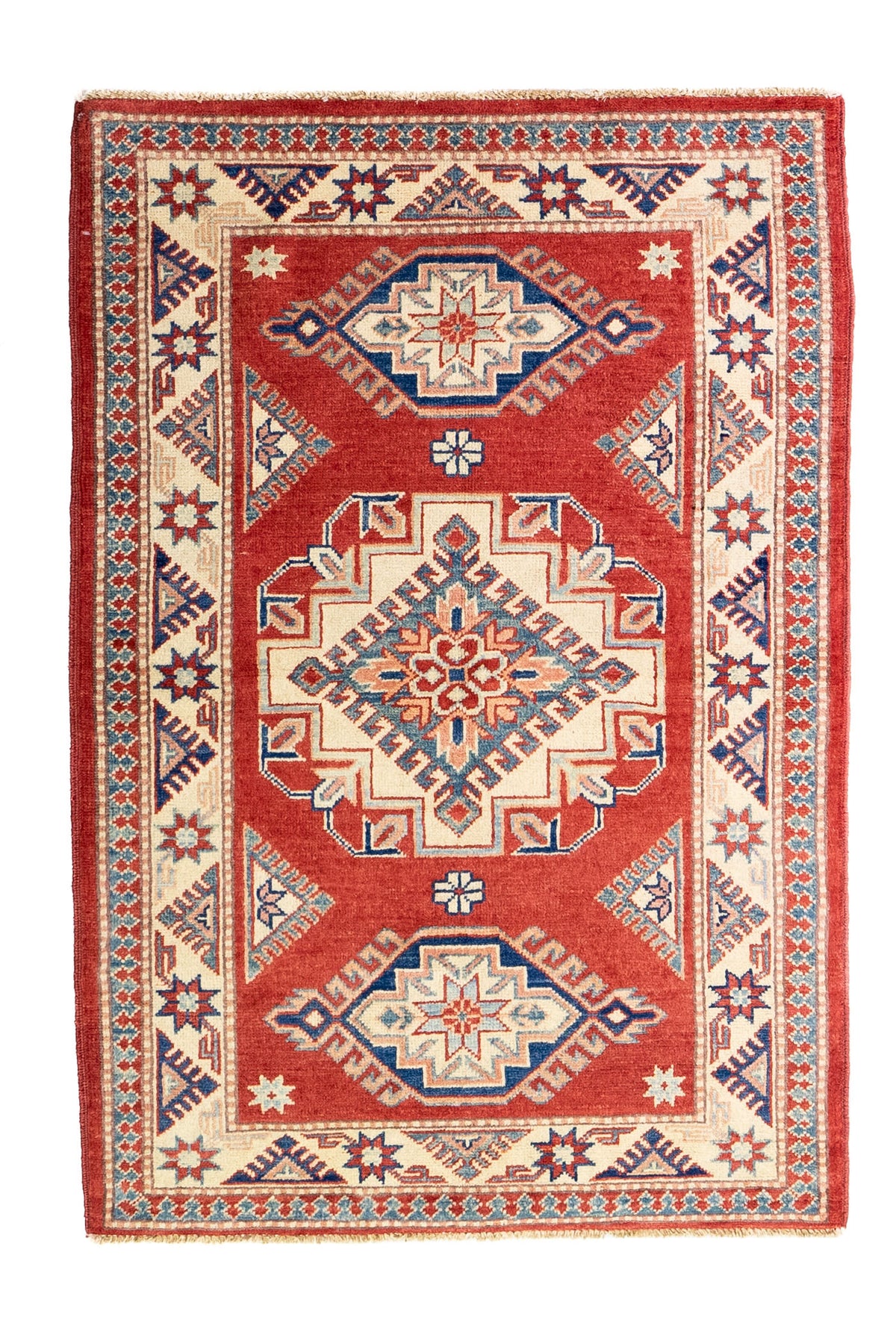 Alfombra Caucasica Kazak ladrillo y beige de 1.04 x 1.47 mts, vista completa vertical; el diseño muestra tres medallones geométricos principales sobre un campo ladrillo con borde beige
