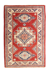 Alfombra Caucasica Kazak ladrillo y beige de 1.04 x 1.47 mts, vista completa vertical; el diseño muestra tres medallones geométricos principales sobre un campo ladrillo con borde beige